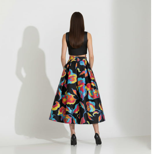 Woman wearing a black top and colorful skirt on a white background