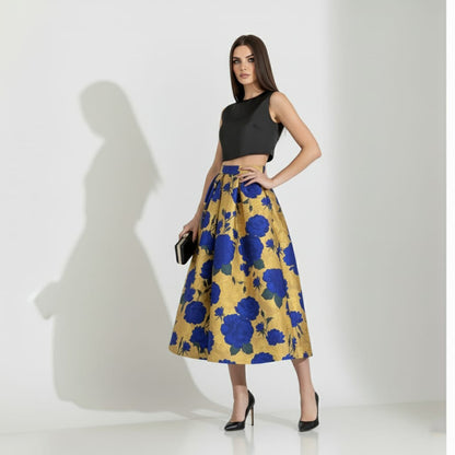 Woman wearing a black top and blue floral golden skirt on a white background