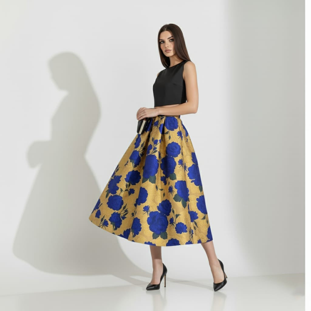 Woman wearing a black top and blue floral golden skirt on a white background