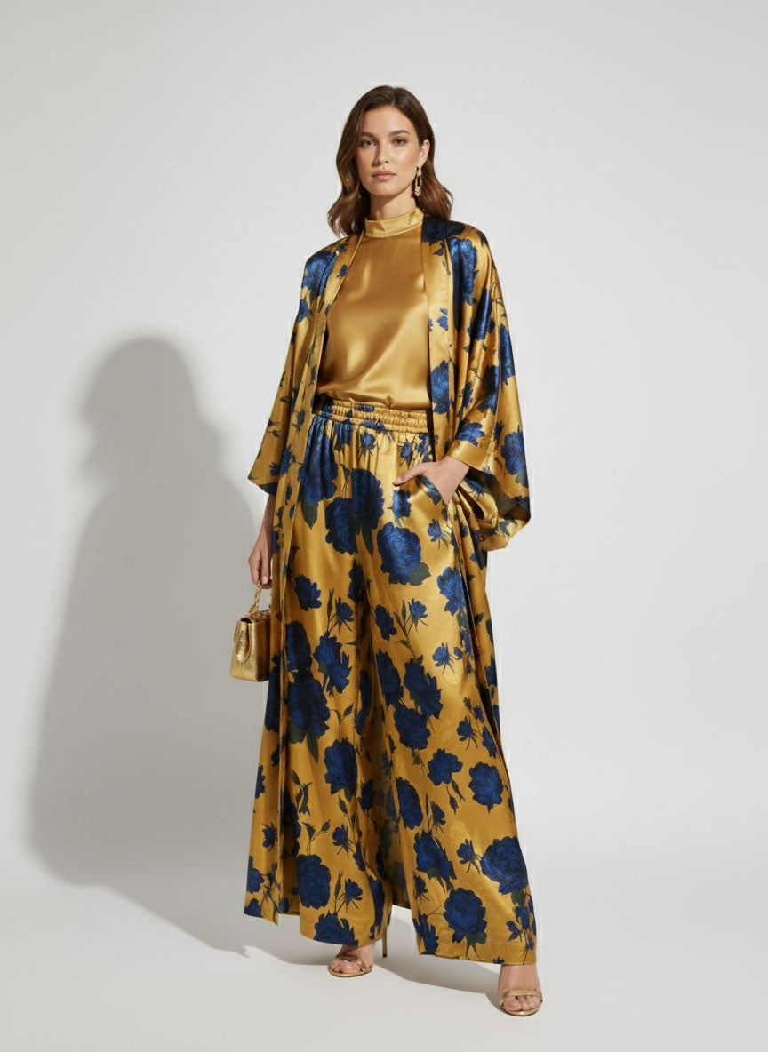 Woman wearing a golden kimono with blue floral pattern on a white background