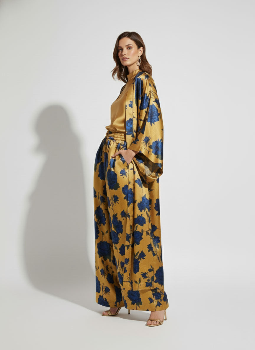Woman wearing a golden kimono with blue floral pattern on a white background