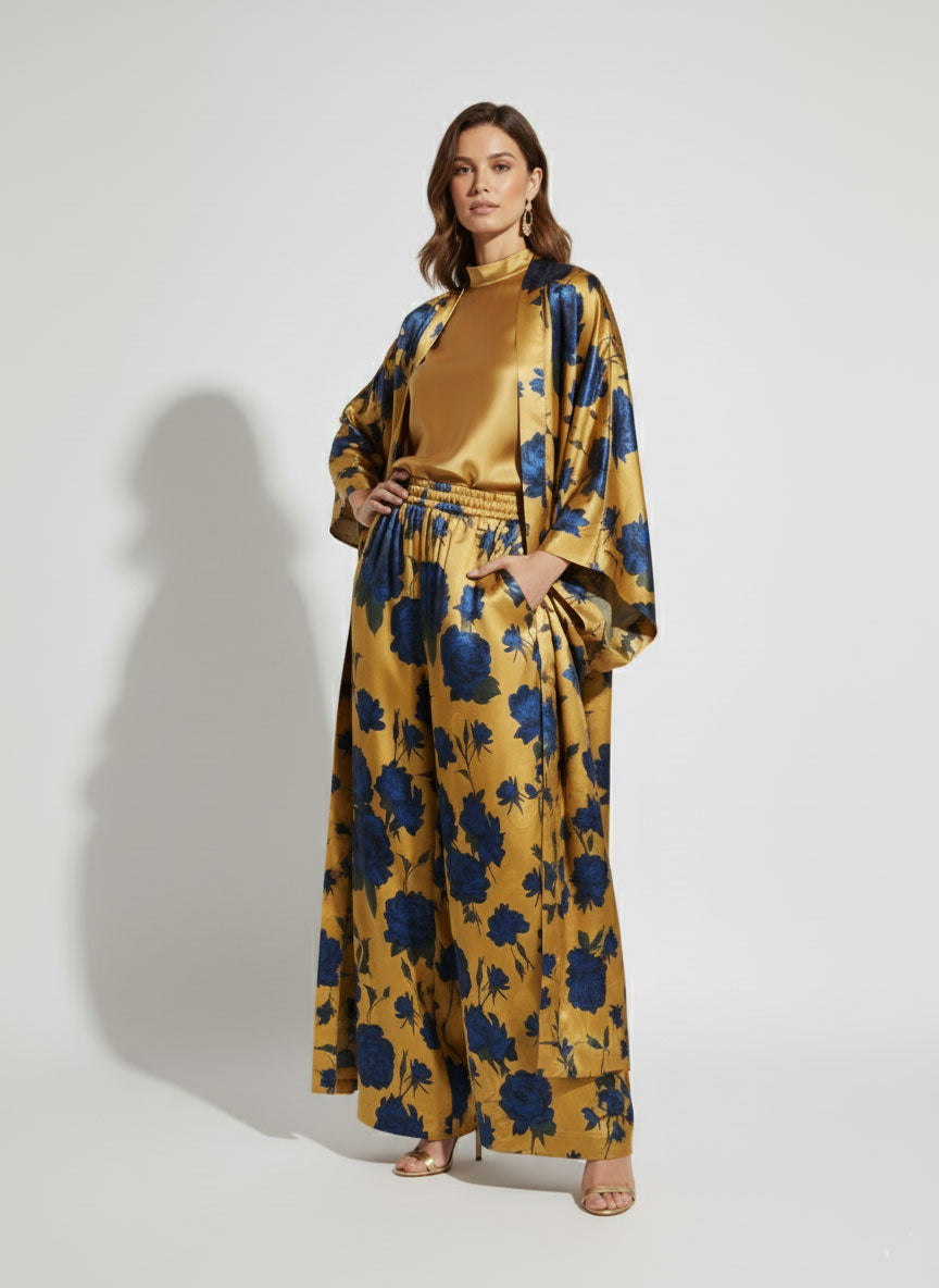 Woman wearing a golden kimono with blue floral pattern on a white background
