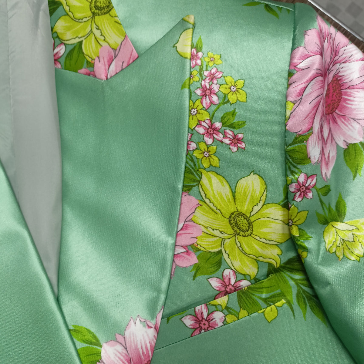 Close-up of floral print pattern on green blazer - ARTSAY