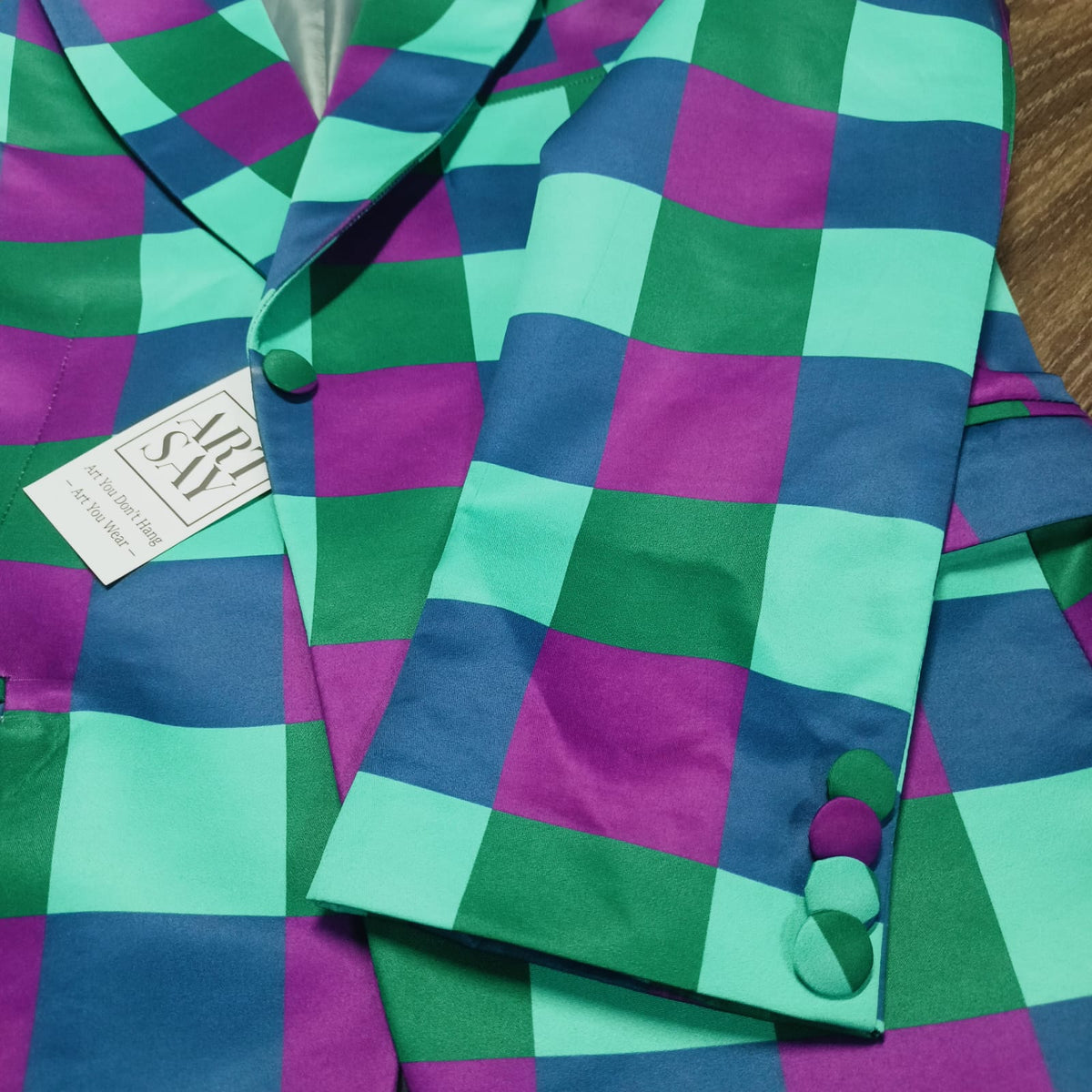 Colorful checkered fabric with a pattern of green, blue, and purple squares.