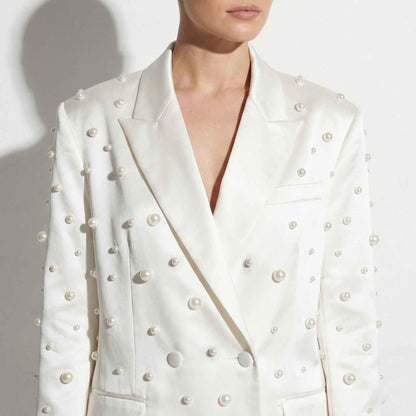 Close-up of pearl detailing on white blazer - ARTSAY